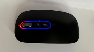 a black wireless mouse viewed from the top, shown the roller and a button to turn on and off the light on the outline of the mouse